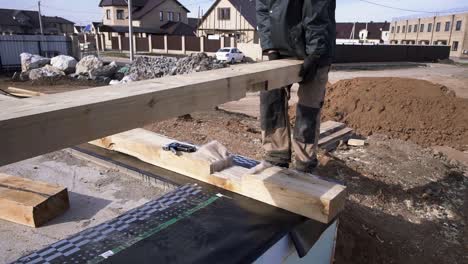 construction workers laying wooden beams on concrete foundation