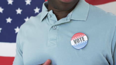 african american man pins a voters badge on his shirt