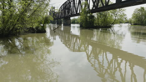 Puente-Reflexionando-Sobre-Las-Tranquilas-Aguas-Del-Río-Arkansas-En-Van-Buren,-Ar,-Ee.uu.---Disparo-De-Drones