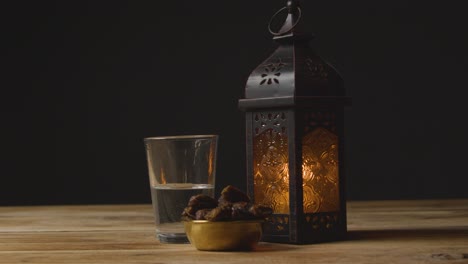 tracking shot of dates water and a lantern on table