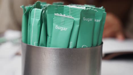 close-up of sugar packets in a metal container