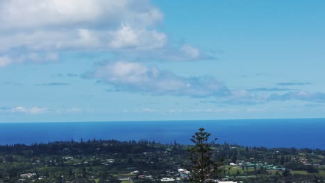 time-lapse of the beautiful landscape of mount pitt in norfolk island, australia with view of the colorful buildings, the forests and passing clouds above the blue sea and view of the horizon