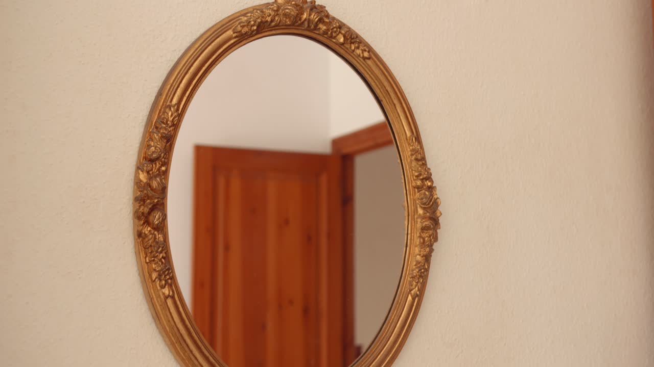 Specchio vintage con cornice dorata appeso al muro