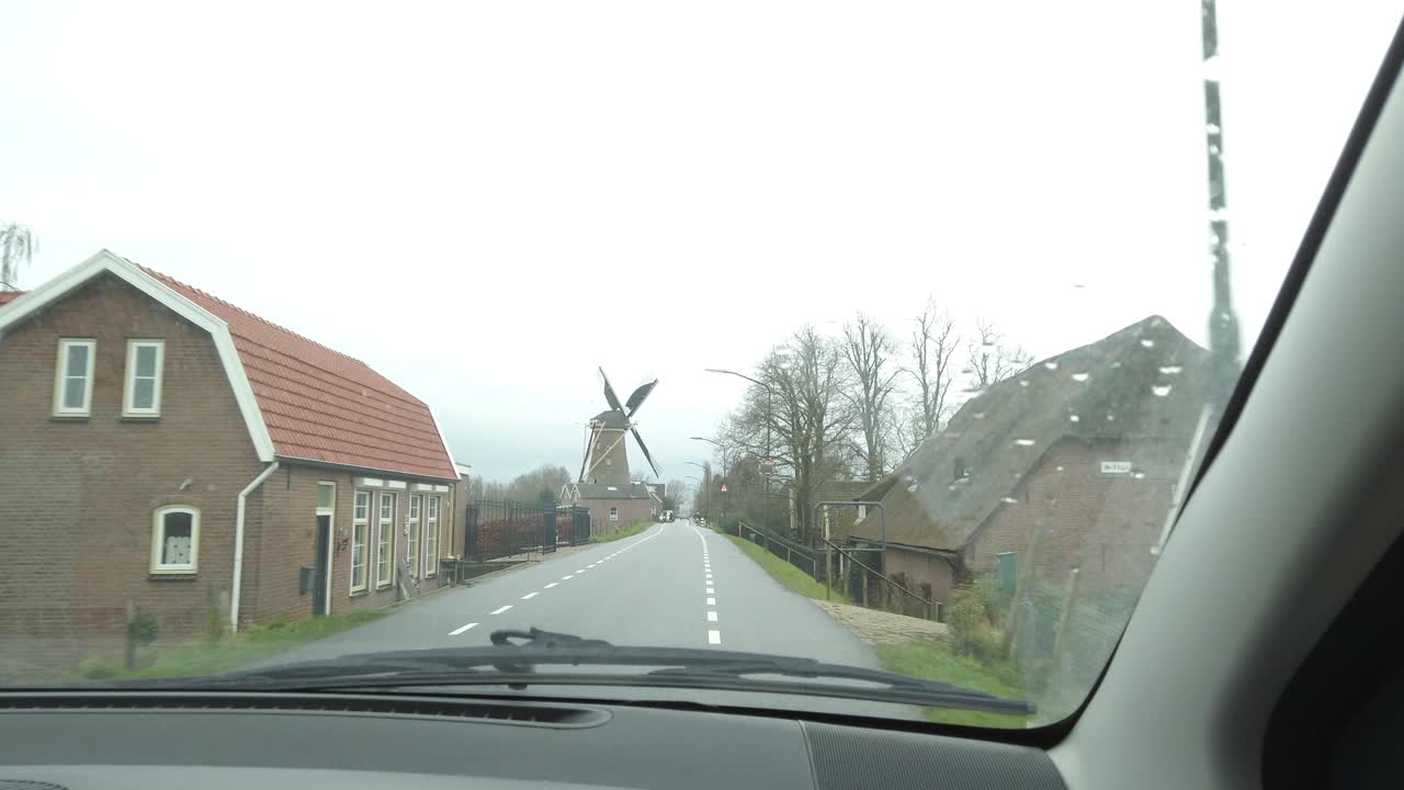 도로 옆에 있는 오래된 고전적인 네덜란드 풍차 전망과 함께 네덜란드의 시골을 통과하는 자동차 장면 내부