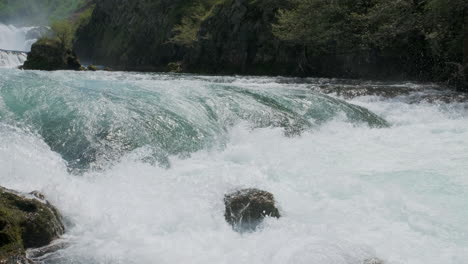 a waterfall with a large amount of water on a clean and wild mountain river