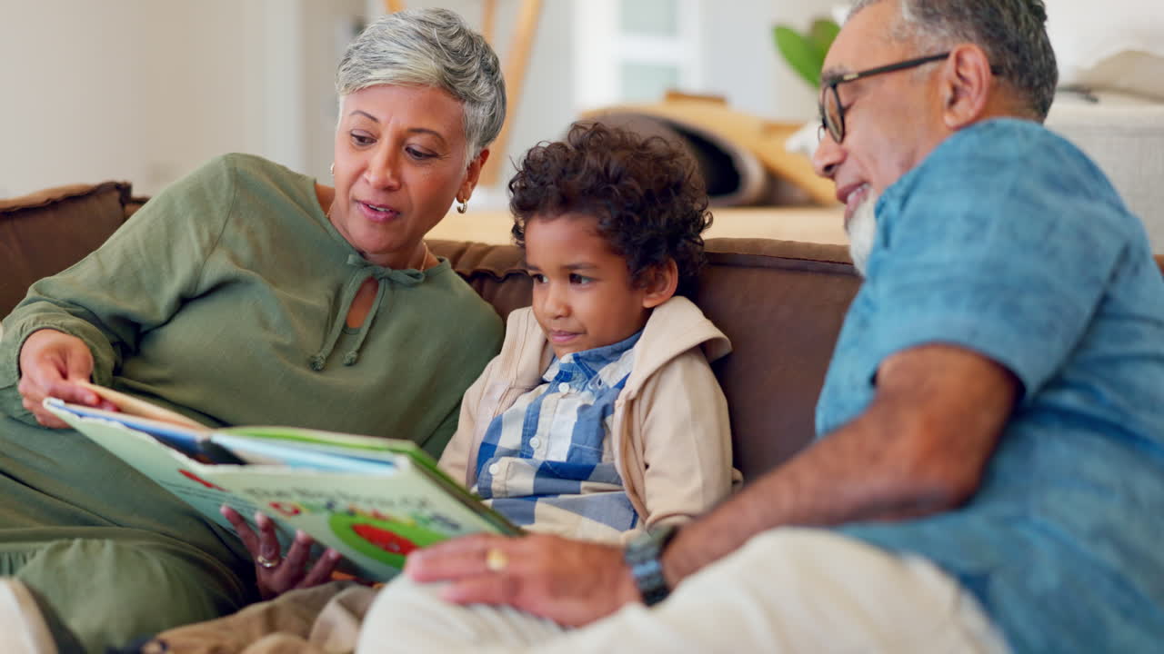 Grandparents, child and reading books on sofa