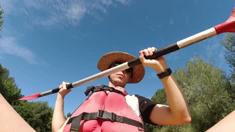 Lustiger-Clip-Eines-Jungen-Mannes,-Der-Mit-Dem-Kajak-Den-Fluss-Entlang-Paddelt