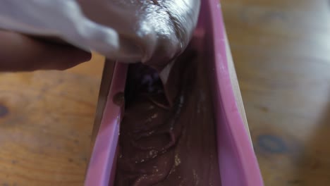 pouring thick cold process soap into the mold for curing