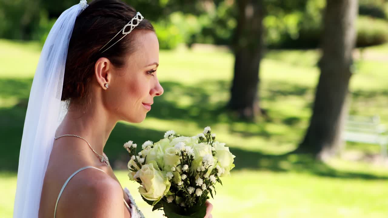 Sposa sorridente che annusa il suo bouquet
