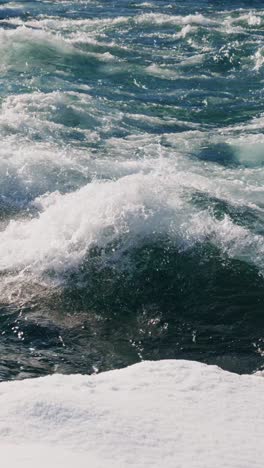 waves crashing against the shore during a bright sunny day at the coastal beach