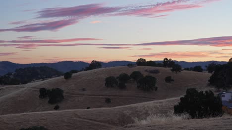 brown rolling hills illuminated by the golden light of sunset. the warm hues and gentle contours of the hills create a peaceful and atmospheric landscape scene