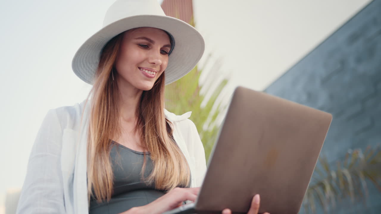 mujer trabajando en la computadora portátil al aire libre