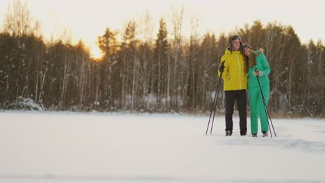 un hombre y una mujer cariñosos esquiando en el bosque invernal realizando actividades al aire libre llevando un estilo de vida saludable. camara lenta