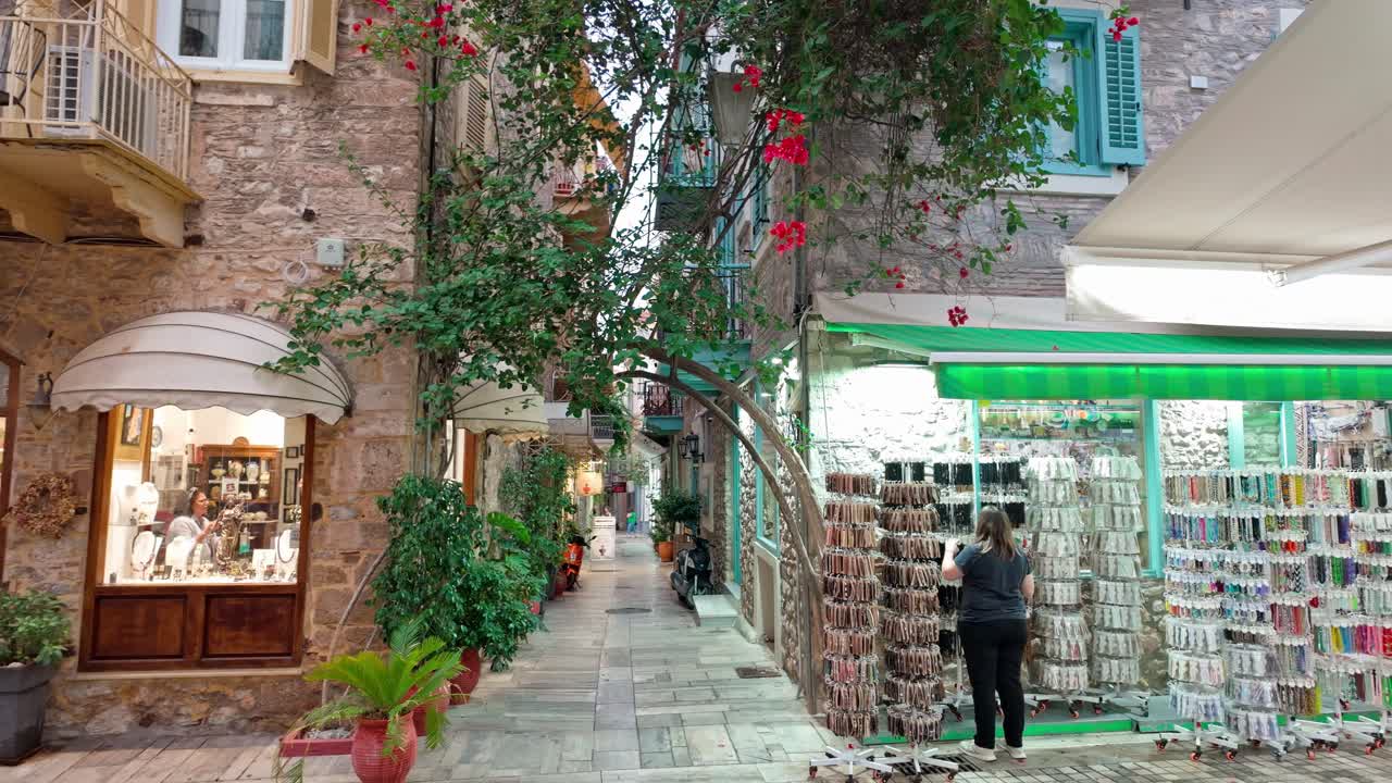 Souvenir boutique shops on pretty Greek narrow floral street ,evening