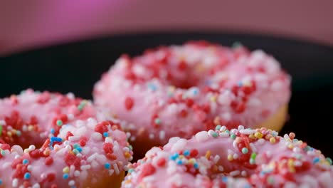 colorful sprinkled pink donuts - sliding shot