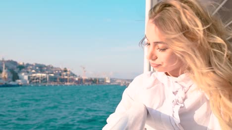 slow motion:beautiful girl enjoys moment while cruising with view of sea on background