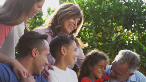 familia hispana de varias generaciones relajándose en el jardín en casa juntos