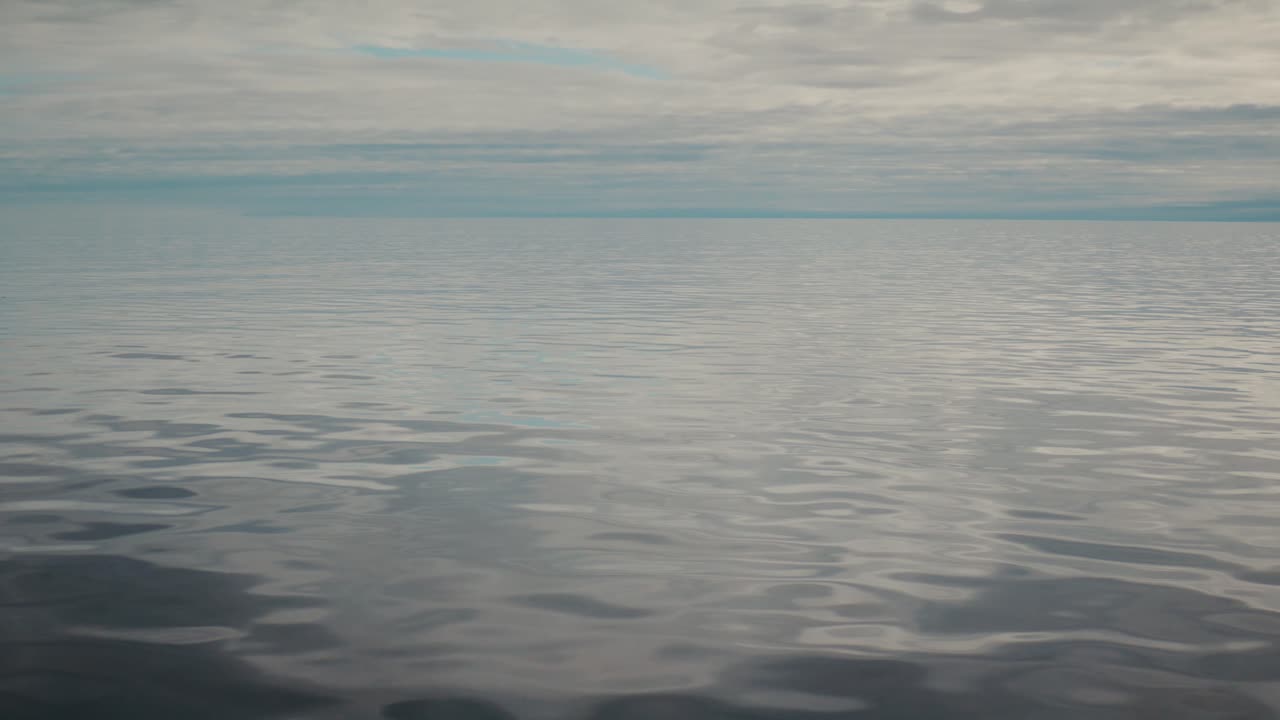 Viajando sobre el tranquilo mar Ártico con una superficie de agua como espejo cerca de Svalbard.