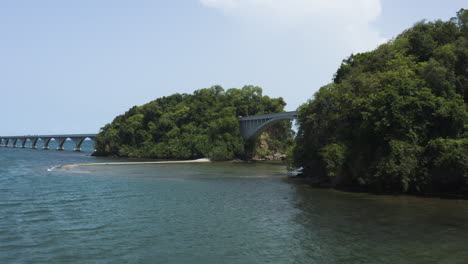 Yate-Hundido-En-La-Costa-De-Samaná-Con-Vistas-Al-Puente-De-La-Nada-En-República-Dominicana---Toma-Aérea