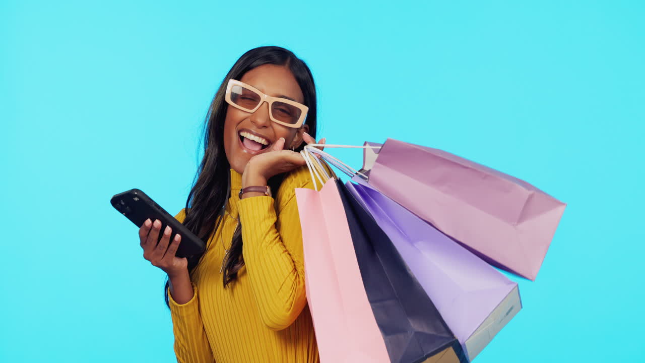 mujer feliz, teléfono y bolsas de compras en el estudio