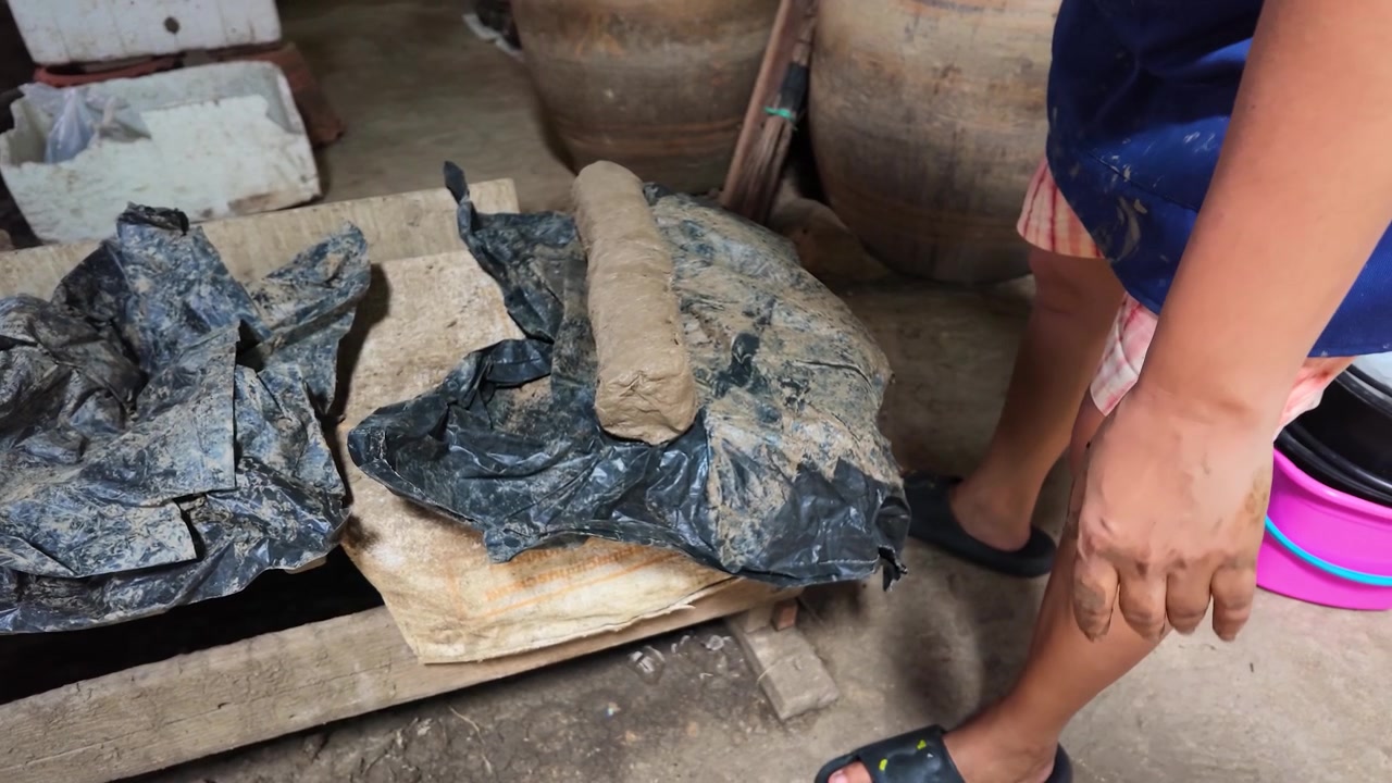 Primo piano di un vasaio che modella argilla grezza sul pavimento di un laboratorio a Nonthaburi, Thailandia