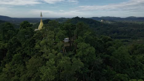 Phra-Maha-Chedi-Thep-Nithakorn,-a-Golden-Thai-Stupa-on-top-of-a-Hill-Surrounded-by-Forest-Trees-in-Saraburi,-Thailand