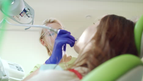 female doctor using dental drill at work