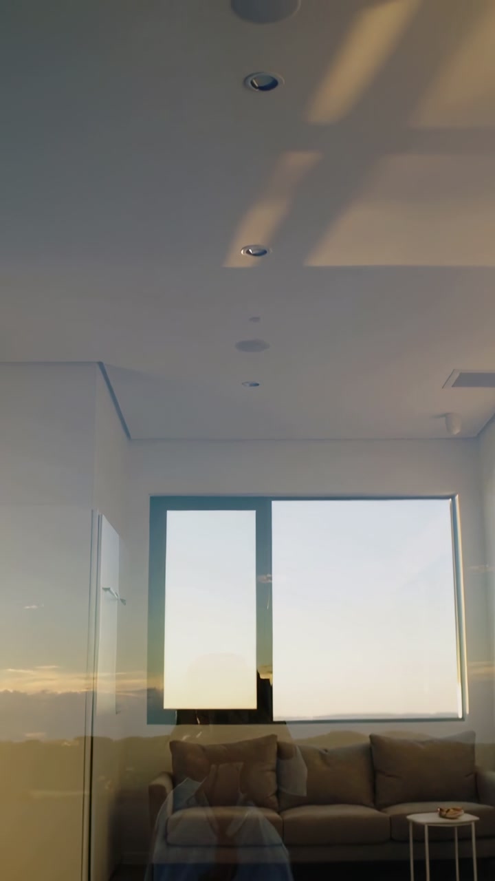 Vertical video: Tilting camera at home to show window, lights and sunset, showing skirt reflection