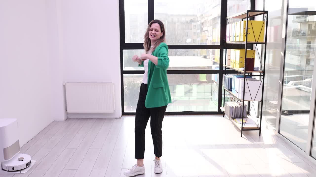 Woman Dancing in Office with Robot Vacuum