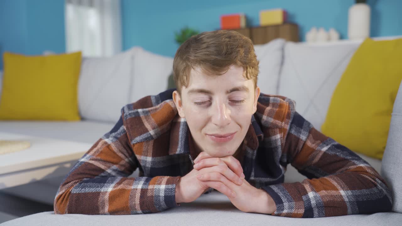 집에 있는 젊은이가 꿈을 꾸고 웃고 있습니다.