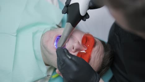 el médico escanea los dientes del paciente en la clínica. el dentista sostiene en su mano un escáner 3d manual para la mandíbula y la boca. salud dental. crea un modelo 3d de dientes y encías en un monitor médico.