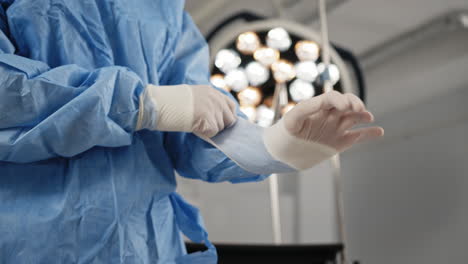 surgeon putting on surgical gloves