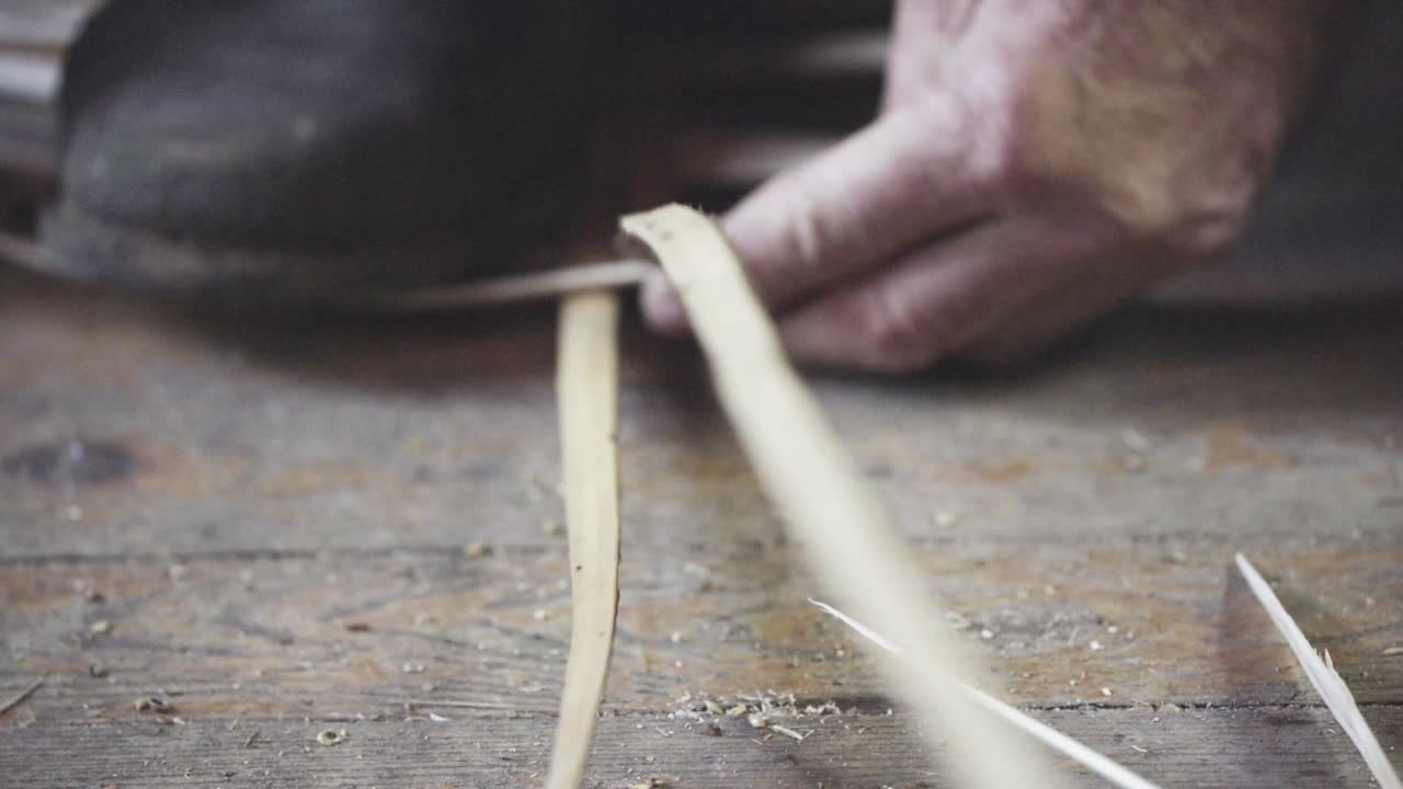 Turkish master weaves baskets from wooden sticks. 4K close-up. Craft concept.