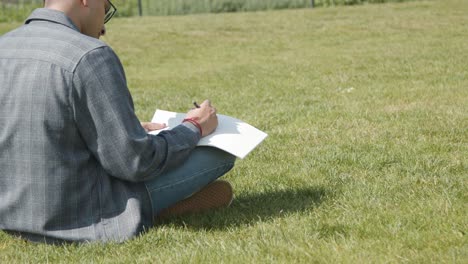 Handheld Shot of a Student Writing Notes In Park