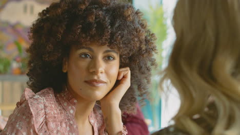 Close-Up-Of-Two-Female-Friends-Meeting-In-Coffee-Shop-And-Talking