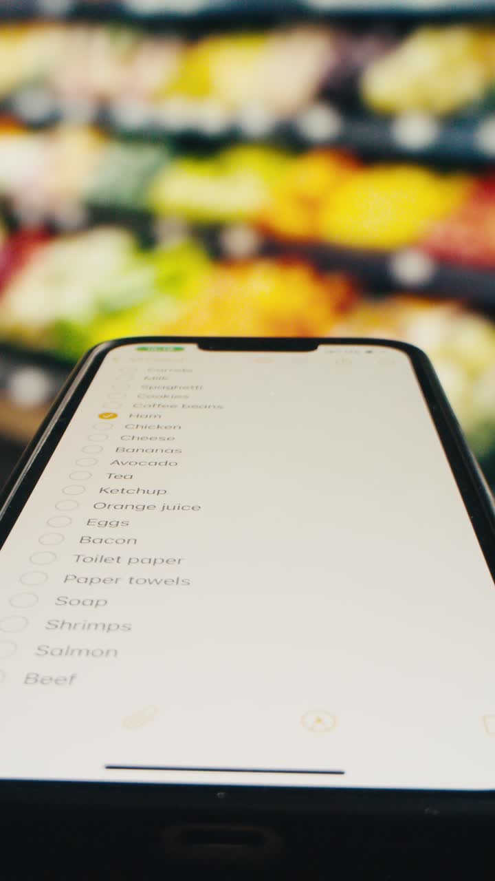 Hand Checking Off Items on Digital Shopping List on Smartphone