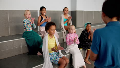 children with swim coach at swimming pool
