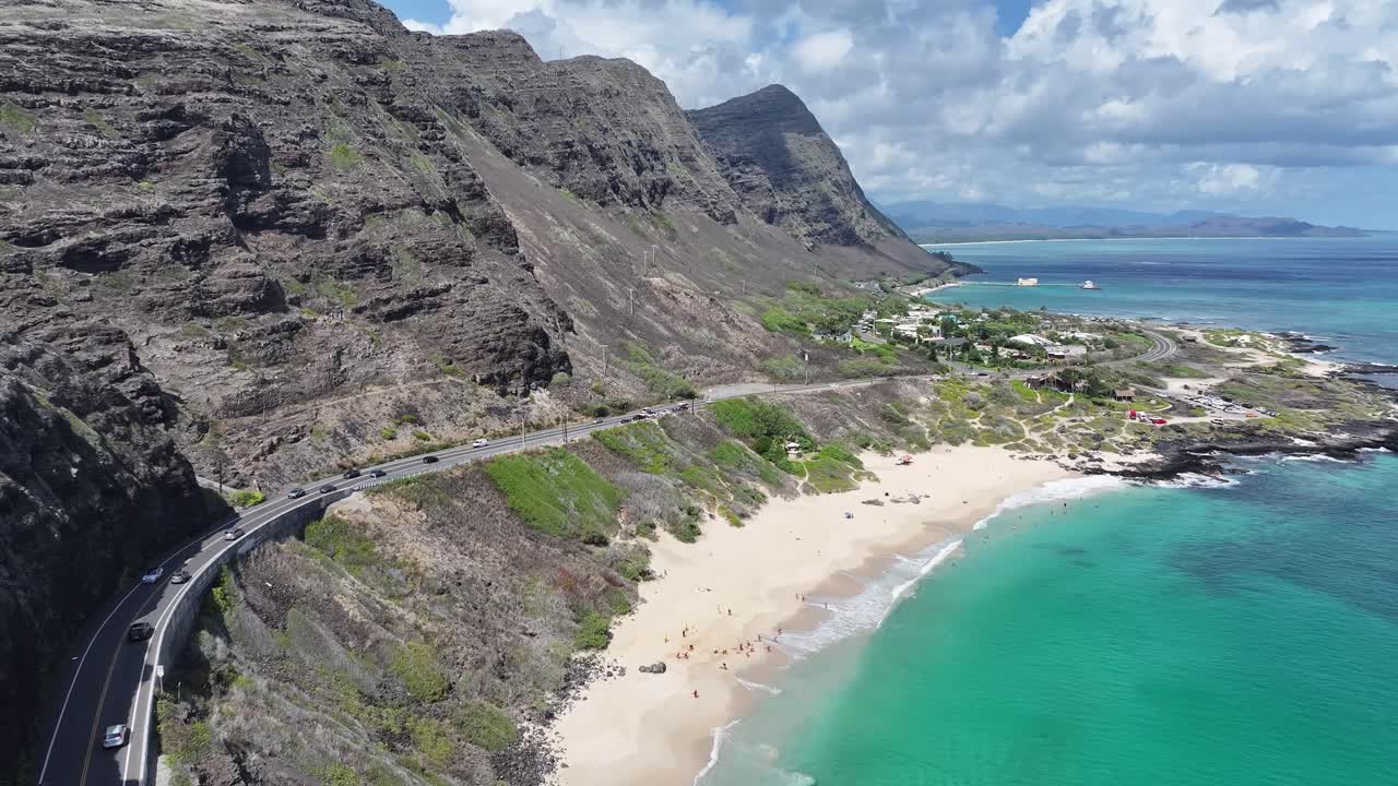 Filmato aereo realizzato con drone sulle lussureggianti montagne verdi e sulla costa tropicale delle Hawaii, che mostra le acque turchesi dell'oceano, le palme, le valli panoramiche e i vivaci paesaggi insulari dall'alto