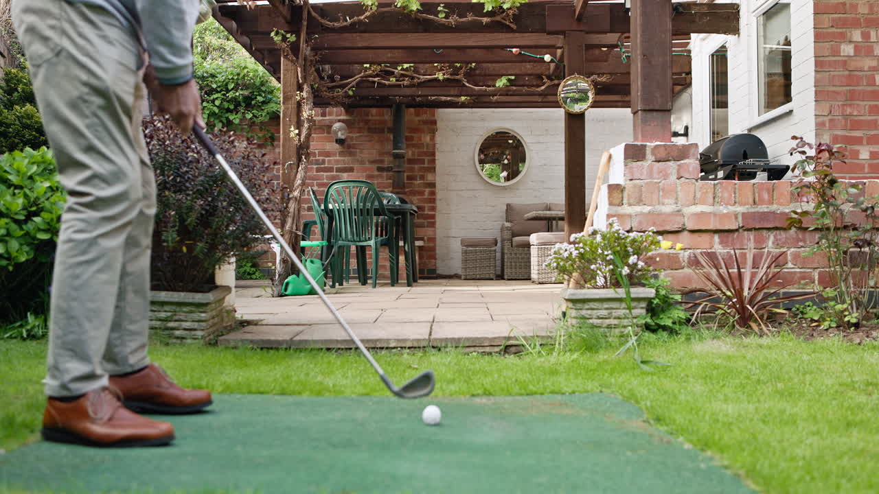 Man Practicing Golf in Backyard