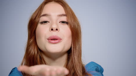 portrait of romantic girl posing indoors. redhead young woman sending air kisses