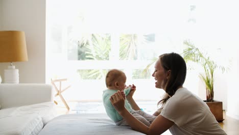 madre alegre entrenando al bebé hija para sentarse