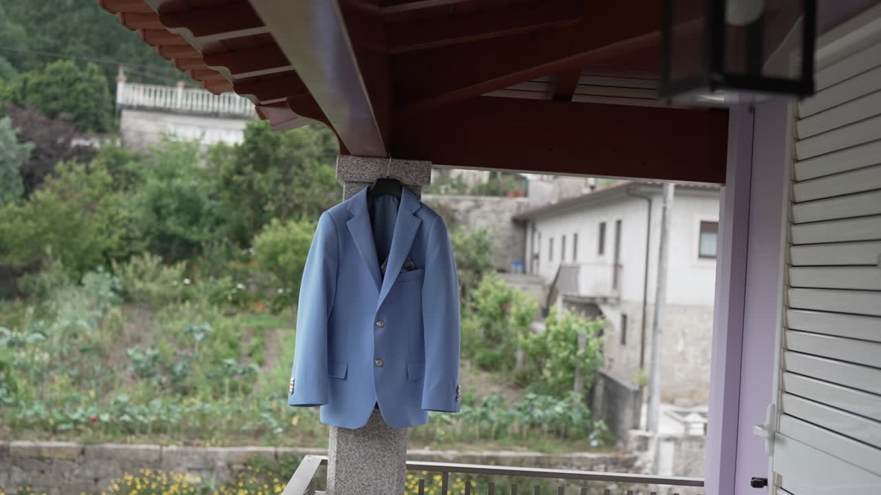 경치 좋은 배경으로 나무 지붕 아래의 기둥에 매달린 밝은 파란색 슈트 재