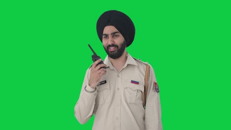 happy sikh indian police man talking on radio green screen