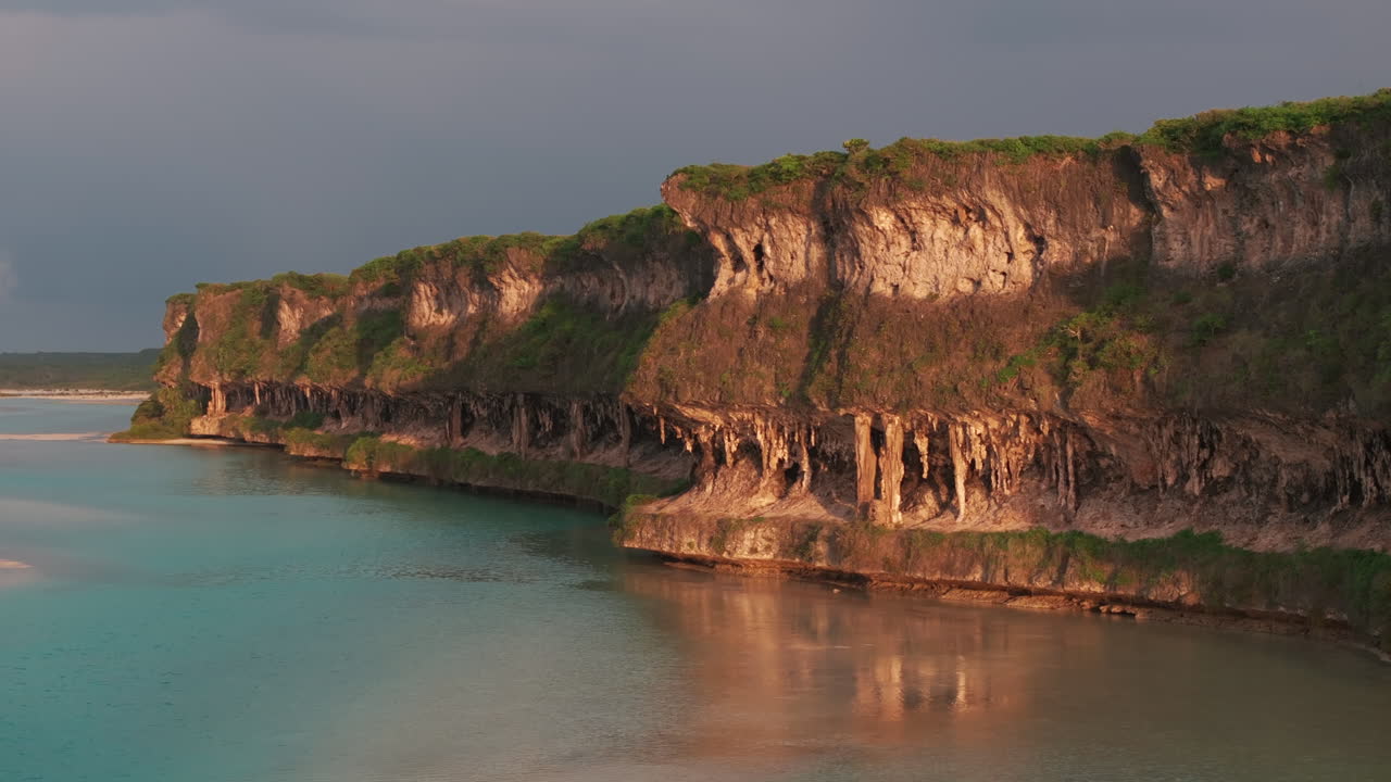 Sunset aerial shot of Lekini Bay, New Caledonia, highlighting dramatic limestone cliffs above turquoise lagoon waters