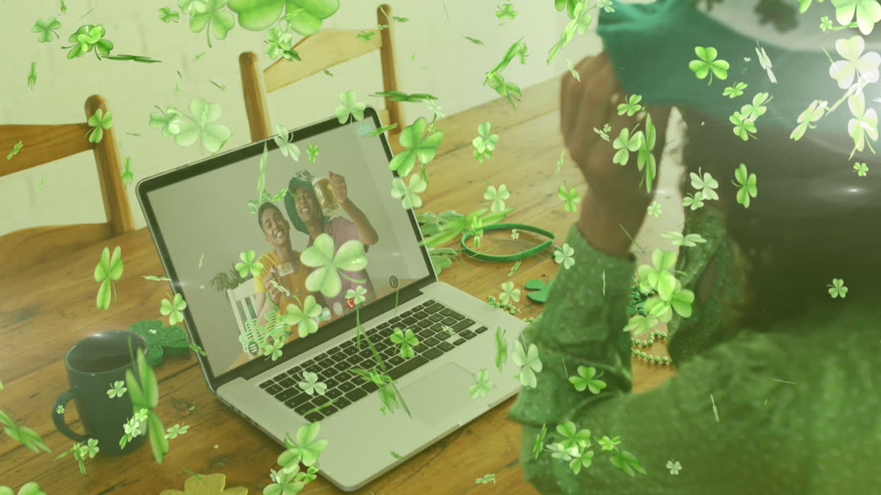 hojas de trébol cayendo contra la mujer que lleva gafas de trébol mientras tiene una videollamada en casa