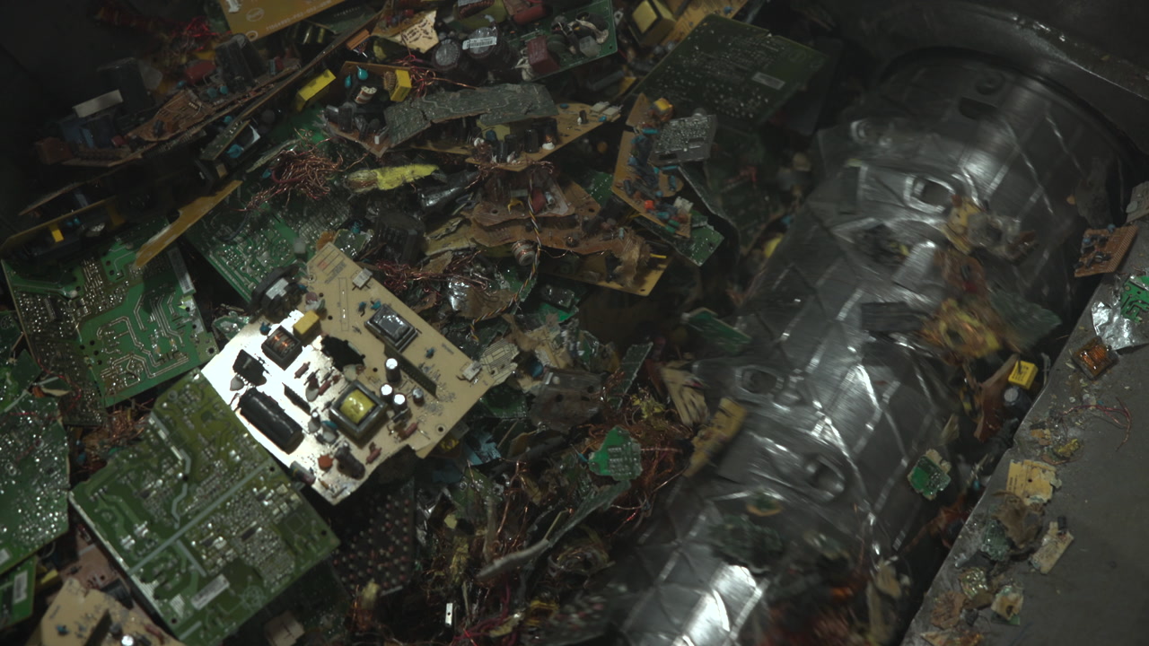 Shredded Circuit Fragments Inside Metal Drum, Closeup Of Fractured PCBs, Copper Strands And Plastic Debris . Media