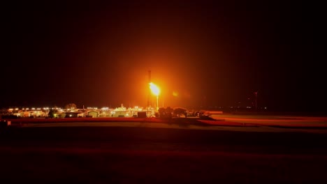 el resplandor radiante de la llamarada de gas ilumina los alrededores cercanos - avión no tripulado volando hacia adelante