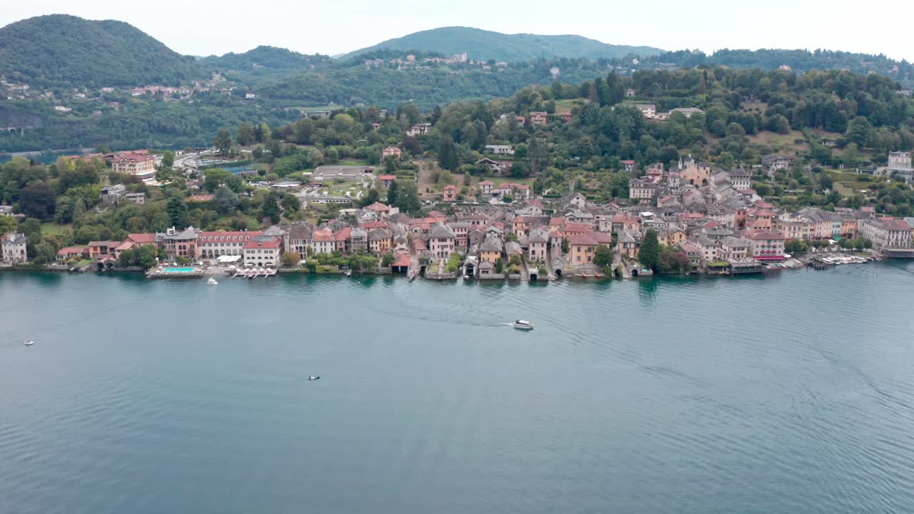 산 줄리오 섬 (isola san giulio) 은 이탈리아의 오르타 호수 (lake orta) 에 있는 섬으로, 초록색 언덕 앞에 놀라운 역사적인 건물들이 있다.