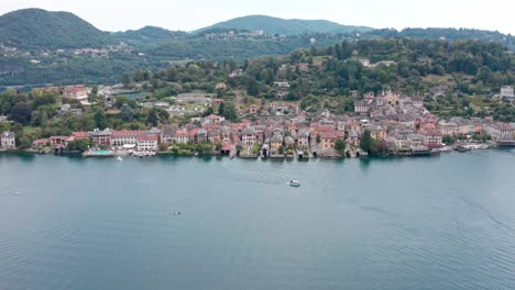 isola san giulio on idyllic lake orta, italy with stunning historic buildings before green hills