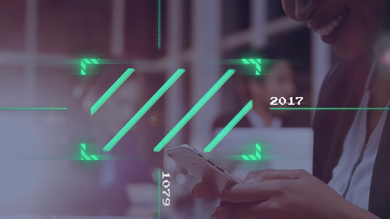 Woman tapping smartphone in tech office, colleagues working behind green HUD overlays